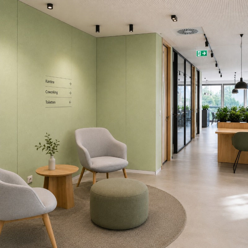 Moderner Büroflur mit Sitzbereich, salbeigrünen Wänden und natürlichem Holzdesign.