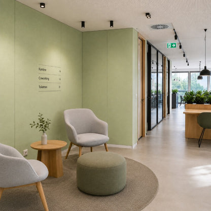 Moderner Büroflur mit Sitzbereich, salbeigrünen Wänden und natürlichem Holzdesign.