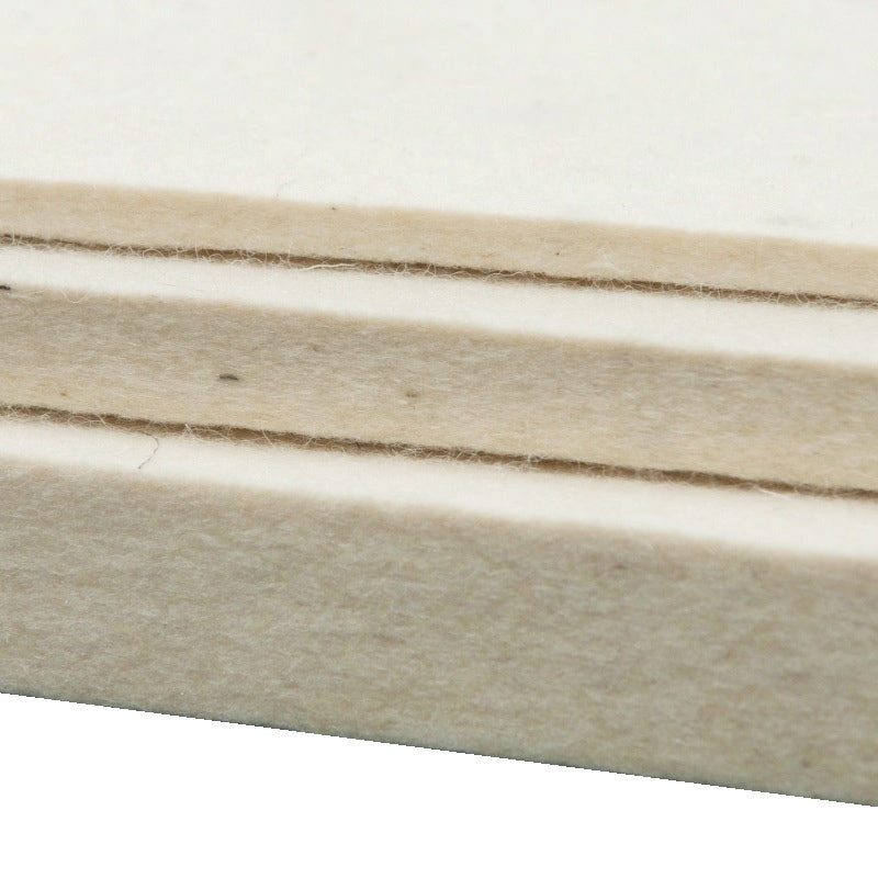 Nahaufnahme von drei hellen, versetzt übereinandergelegten Merinofilzplatten in unterschiedlichen Stärken.