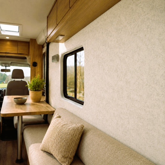 Innenraum eines Wohnmobils mit beige-melierter Filzverkleidung und hellen Möbeln.